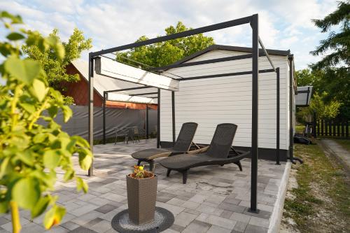 a patio with two chairs and a gazebo at Diófa Vendégház in Pilismarót