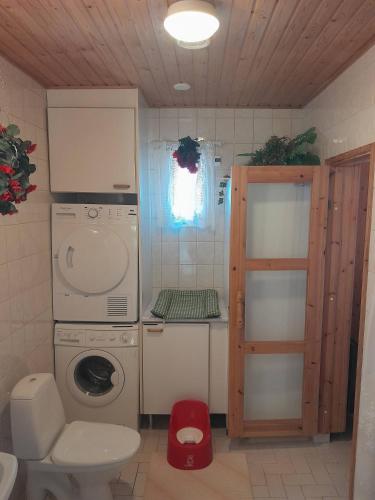 a small bathroom with a washing machine and a washer at Suns Tupa - Travellers Marmalade in Siikalatva