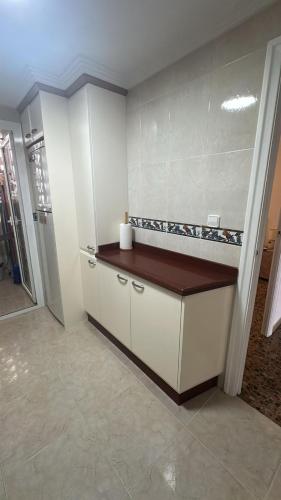 a kitchen with white cabinets and a brown counter top at Apartamento entero en la playa san juan in Alicante