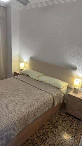 a bedroom with a bed with two tables and two lamps at Apartamento entero en la playa san juan in Alicante