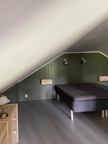 a bed in a room with a green wall at Gårdshus på Kilagårds Gröna in Heberg