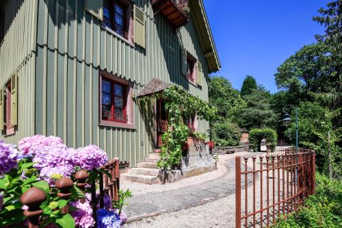 a green building with flowers in front of it at la maison oubliée in Goetzenbruck