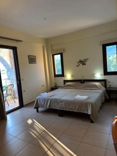 a bedroom with a large bed and a large window at Xenonas Anopolis 2 in Sinoikismós Kámbos