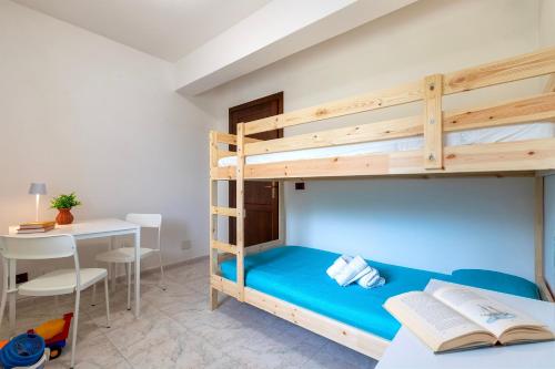 a bedroom with a bunk bed with a desk and a table at Harmony in Nulvi