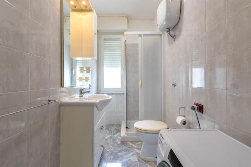 a white bathroom with a sink and a toilet at Harmony in Nulvi