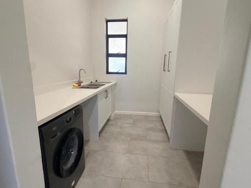 a laundry room with a washer and dryer in it at Dreams Apartments in Victoria Falls
