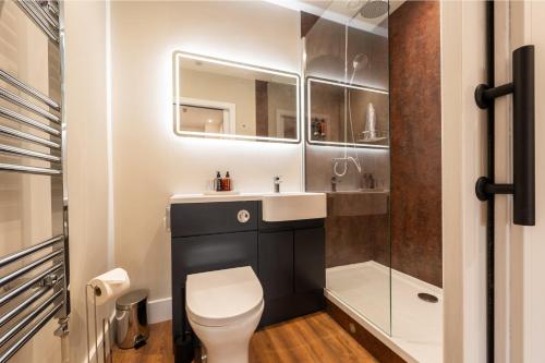 a bathroom with a toilet and a sink and a shower at Parade House - A St David Aparthotel in Barrow in Furness