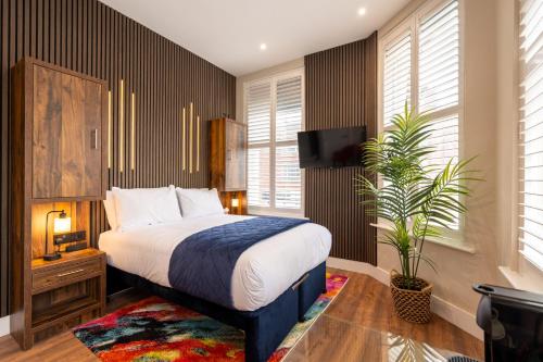 a bedroom with a bed and a plant at Parade House - A St David Aparthotel in Barrow in Furness