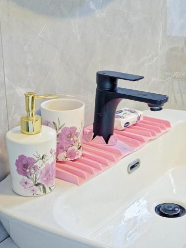 a sink with a faucet and two cups on it at Villa Lea in Bihać