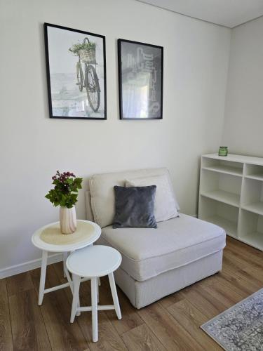 a living room with a couch and a table at Vilimiškės Apartamentai in Palanga