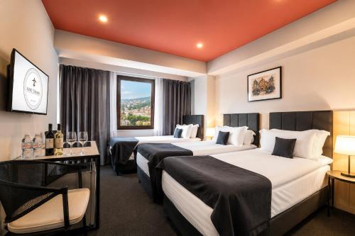 a hotel room with two beds and a window at King Tamar Hotel By Luxuria Hotels in Tbilisi City