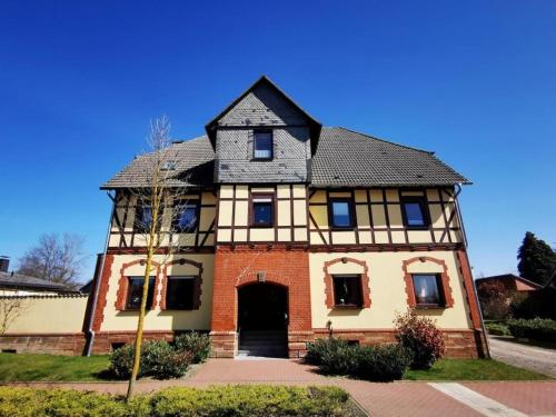 an old house with a black roof and a brick building at Ferienwohnung Vielfalt in Höringhausen