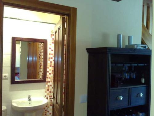 a bathroom with a sink and a mirror at La Casuca de Pechón in Pechón