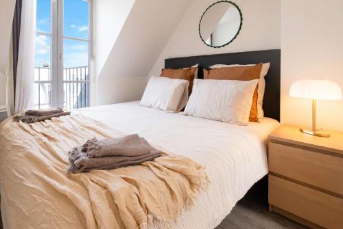 a bedroom with a large white bed with a mirror at Sebastopol Chic Balcon & Parisian View in Paris