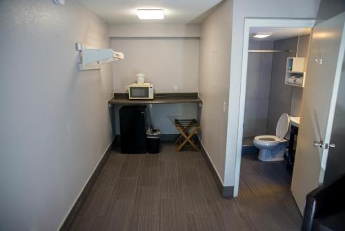 墨爾本的住宿－大西洋汽車旅館，一间带卫生间、水槽和微波炉的浴室