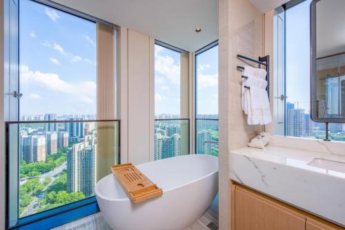 a bathroom with a white tub and a large window at 融域公寓-南京博览中心店 in Nanjing