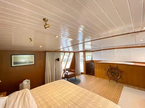 a bedroom of a boat with a bed and a desk at The Oak & Anchor - Hong Kong Houseboat in Hong Kong