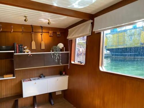 a room with a table and a window in a boat at The Oak & Anchor - Hong Kong Houseboat in Hong Kong