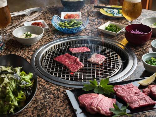 a grill with meat and vegetables on a table at Art Hotel Ishigakijima in Ishigaki Island