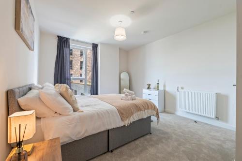 a bedroom with a large bed and a window at Stylish 1-Bed flat with Private Balcony in Hatch End