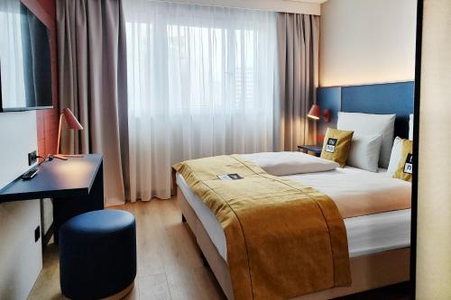 a hotel room with a bed and a desk at the niu Clink in Hamburg