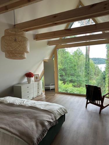 a bedroom with a bed and a large window at Mezi Smrky in Bohostice