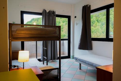 a room with two bunk beds and a window at Valsesia Hostel in Scopello