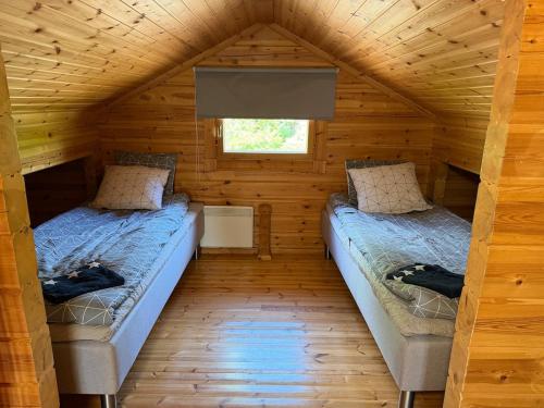 a room with two beds in a log cabin at Villa Predium renovated cottage for four in Raseborg