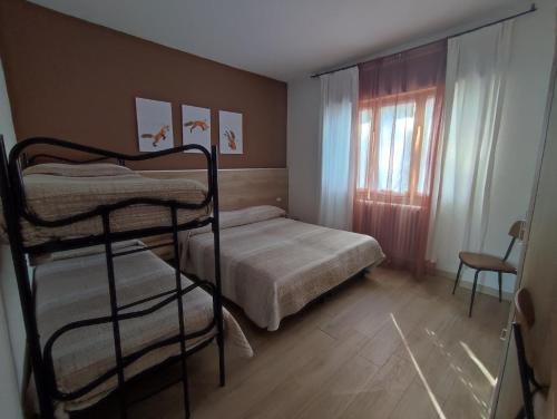 a bedroom with two bunk beds and a window at Albergo Ristorante Sargas in Cevo