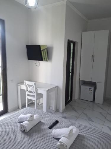 a white room with a desk and a bed with towels at ilios in Kobuleti