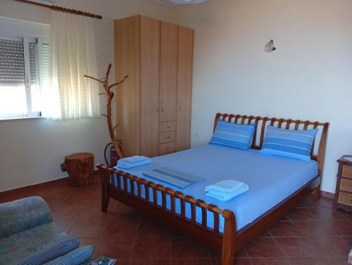 a bedroom with a large bed with blue pillows at Kalivakia View in Tsoukalades