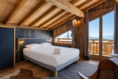 a bedroom with a large white bed and large windows at Splendide châlet neuf avec jaccuzzi in Bolquere Pyrenees 2000
