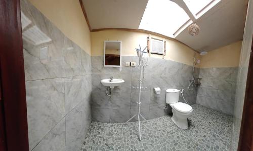 a bathroom with a toilet and a sink at Bareng Homestay Tetebatu in Tetebatu