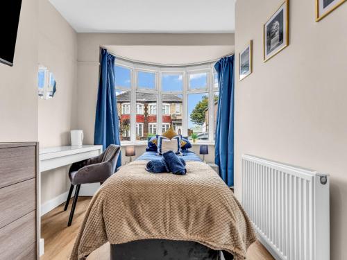 a bedroom with a bed with blue curtains and a window at LetSavvy Contractor Accommodation Hartlepool in Hartlepool