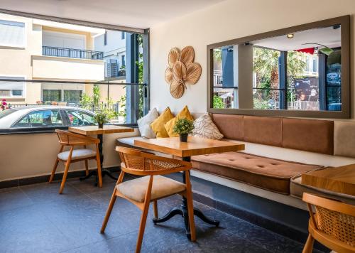 a restaurant with a couch and tables and a window at Mielo Lara Hotel in Antalya