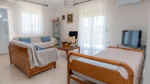 a bedroom with a bed and a couch and a tv at Nice & Cosy apartment in Igoumenitsa in Igoumenitsa