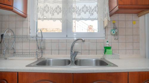 a sink in a kitchen with a window at Nice & Cosy apartment in Igoumenitsa in Igoumenitsa