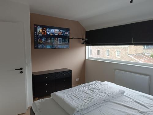 a bedroom with a bed and a tv on the wall at Chez nous a Durbuy in Durbuy