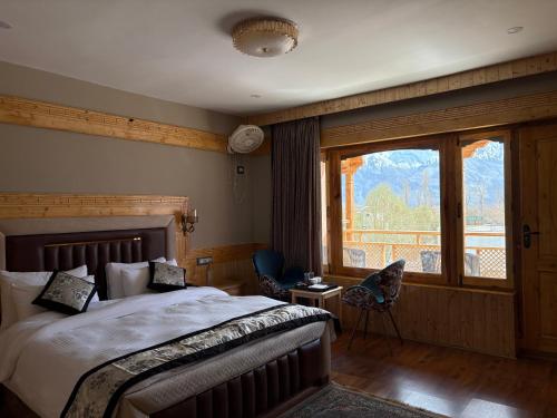 a bedroom with a bed and a large window at Lavender House in Nubra