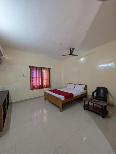a bedroom with a bed and a window at Sona Rooms in Tiruchirappalli