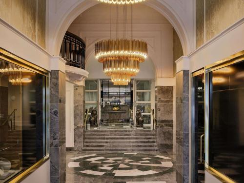 a lobby with a staircase and chandelier at Fable Auckland, MGallery in Auckland