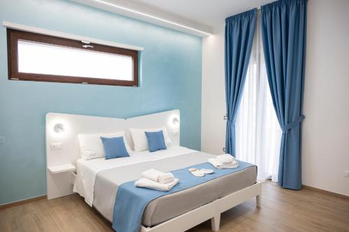 a blue bedroom with a bed with towels on it at B&B Melavì in Lizzano