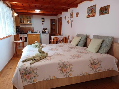 a bedroom with a bed with a stuffed animal on it at Fenyő Kuckó in Bodony