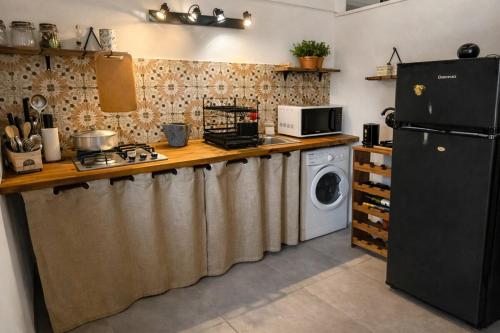 a kitchen with a refrigerator and a washing machine at Tite Case Désirée in Petite Île