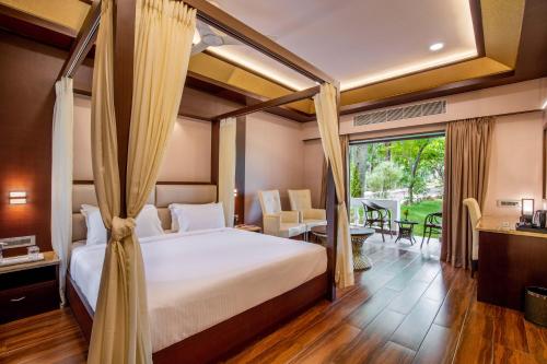 a bedroom with a bed and a table and chairs at Avana Resort in Mettuppālaiyam