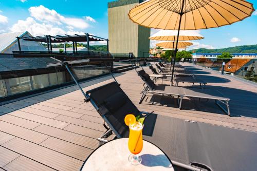 a table with a drink on top of a roof at Hotel Spa & Events Imperial Sighișoara in Sighişoara