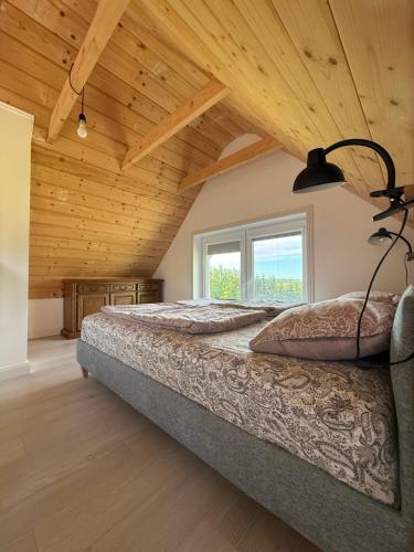 a bedroom with a bed and a large window at Domek letniskowy in Kolno