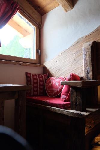 a red couch in a room with a window at B&B Borgo Saint-Rhémy in Saint-Rhémy-en-bosses