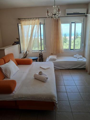 a bedroom with two beds and a chandelier at Orizzonte Apartments Lefkada in Lefkada