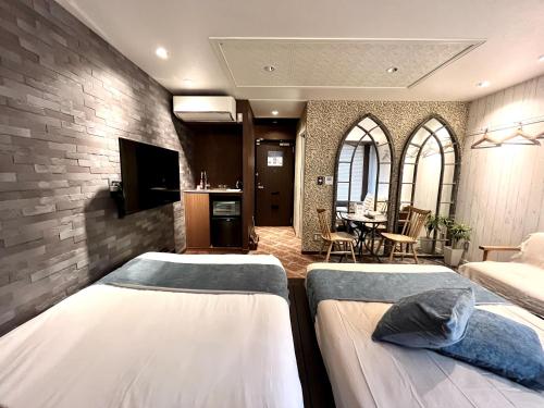 a hotel room with two beds and a kitchen at Beautemps in Osaka